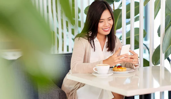 Aziatische vrouw met smartphone in café of koffieshop — Stockfoto