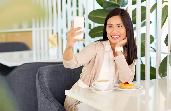 카페에서 스마트 폰으로 셀카를 찍는 아시아 여성 — 스톡 사진
