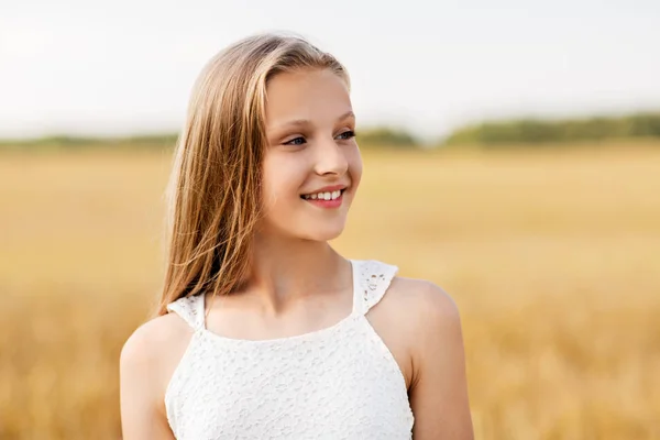 Uśmiechnięta młoda dziewczyna na polu zbożowym w lecie — Zdjęcie stockowe
