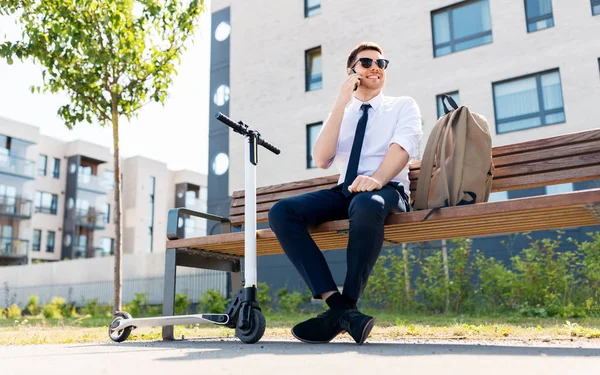 Hombre de negocios con scooter llamando en el teléfono inteligente — Foto de Stock