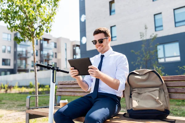 Biznesmen z tabletem, torbą i skuterem — Zdjęcie stockowe