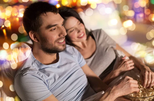 Par med popcorn titta på tv på natten hemma — Stockfoto