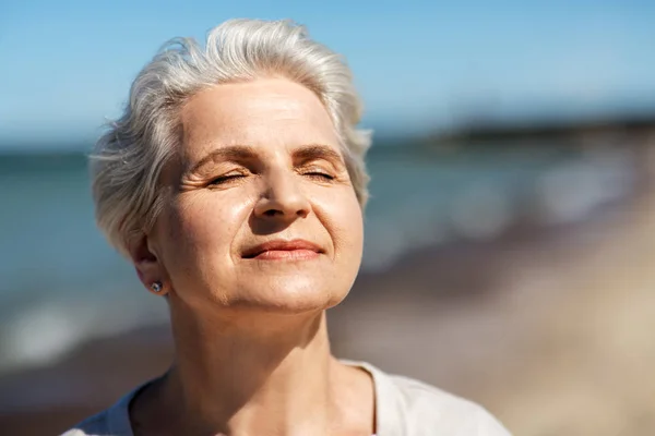 Портрет старшої жінки, насолоджуючись сонцем на пляжі — стокове фото