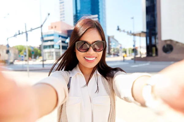 Smiling woman in sunglasses taking selfie in city — Stock Photo, Image