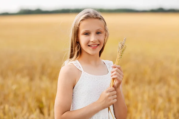 Дівчина зі шматочком пшениці на зерновому полі — стокове фото