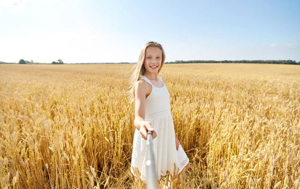 Gelukkig meisje nemen selfie op graanveld — Stockfoto