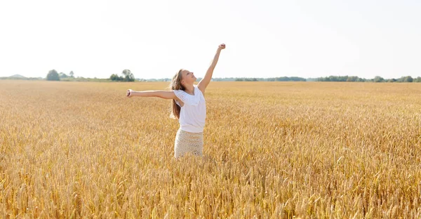 Happy smiling young girl on cereal field in summer Stock Photo