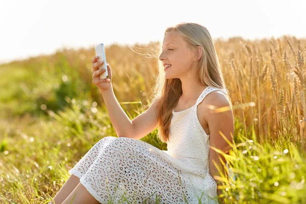 Mutlu genç kız akıllı telefon ile selfie alarak — Stok fotoğraf