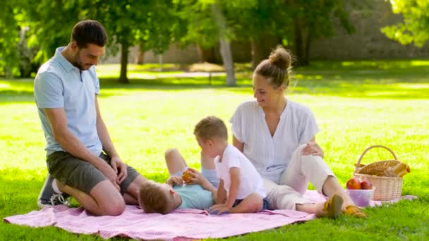 Lycklig familj som har picknick på sommarparken — Stockvideo