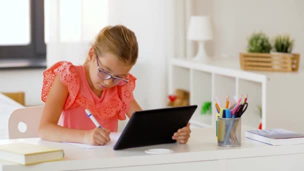 Chica con la escritura de la PC tableta a la libreta en casa — Vídeo de stock