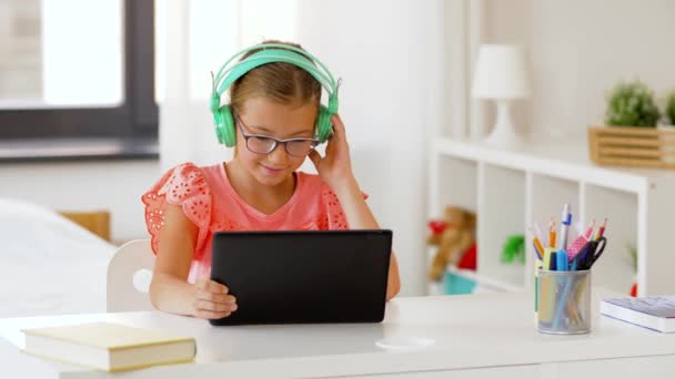 Chica en auriculares con tablet en casa — Vídeos de Stock