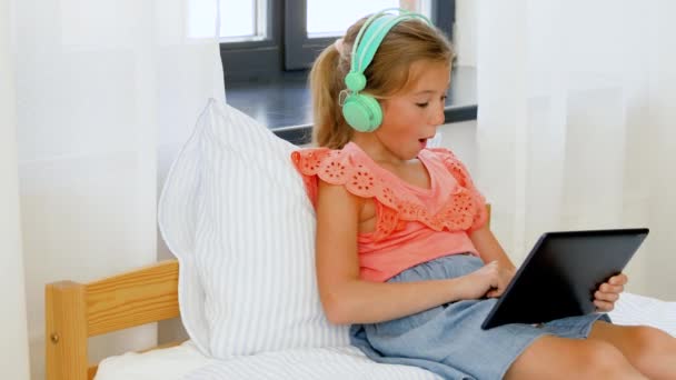 Girl in headphones listening to music on tablet pc — Stock Video