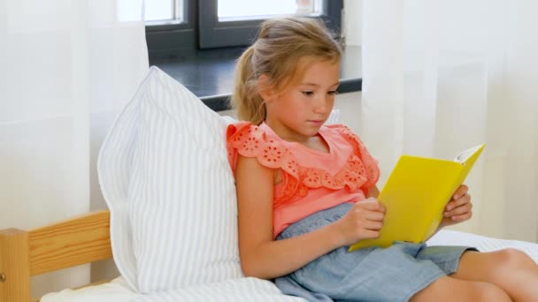 Happy Little Girl czytanie książki w domu — Wideo stockowe