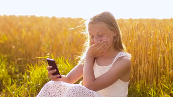 Felice ragazza con smartphone sul campo di cereali — Video Stock