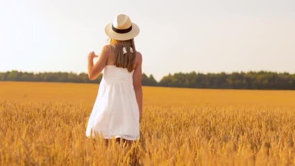 Fille heureuse en chapeau de paille marchant le long du champ de céréales — Video