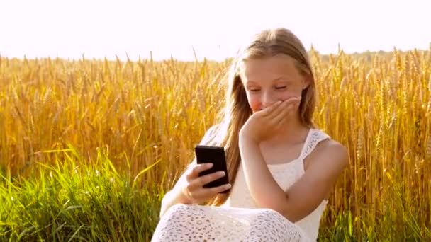 Šťastná mladá dívka s smartphone na cereálie — Stock video