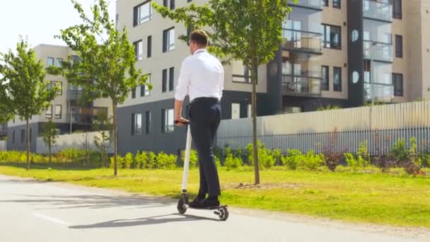 Joven hombre de negocios montar scooter eléctrico al aire libre — Vídeos de Stock