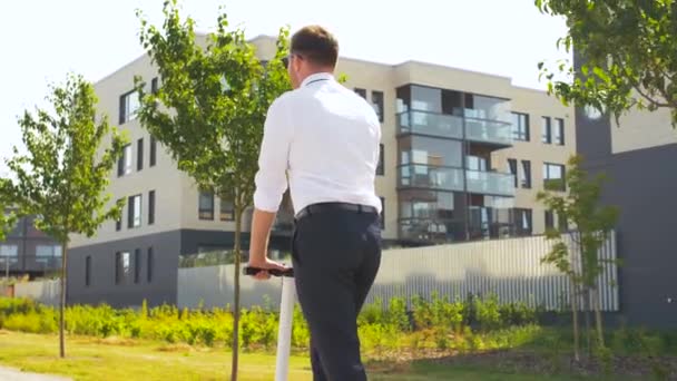 Joven hombre de negocios montar scooter eléctrico al aire libre — Vídeos de Stock