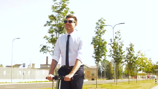 Joven hombre de negocios montar scooter eléctrico al aire libre — Vídeos de Stock