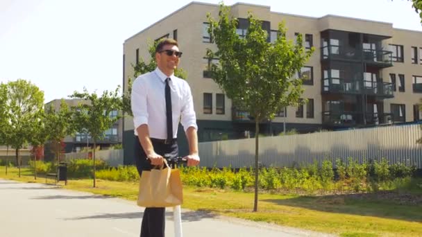 Homem de negócios com takeaway almoço equitação scooter — Vídeo de Stock