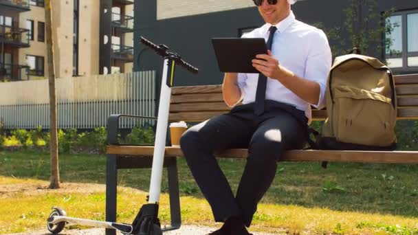 Hombre de negocios con tablet pc, auriculares y scooter — Vídeo de stock