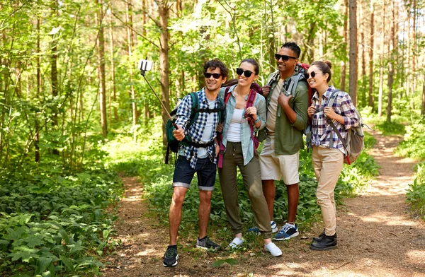 Amigos con mochilas senderismo y tomar selfie — Foto de Stock