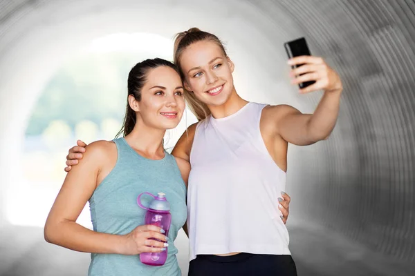 Sportowe kobiety biorąc selfie przez smartfona na zewnątrz — Zdjęcie stockowe