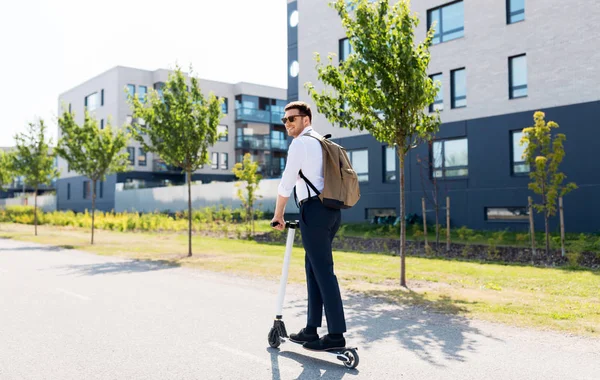 Zakenman met rugzak rijden elektrische scooter — Stockfoto