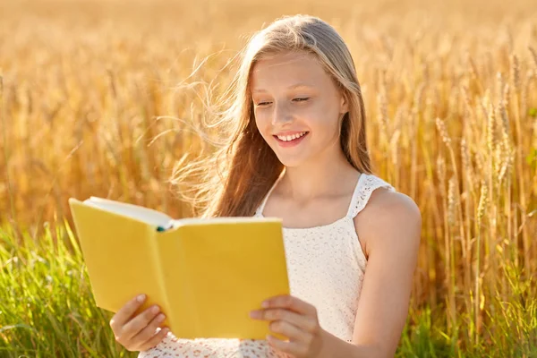 微笑的年轻女孩读麦片领域的书 — 图库照片