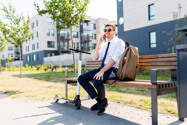 Hombre de negocios con scooter llamando en el teléfono inteligente — Foto de Stock