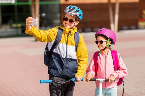 Gelukkige schoolkinderen met scooters die selfie maken — Stockfoto