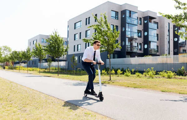 Joven hombre de negocios montar scooter eléctrico al aire libre —  Fotos de Stock