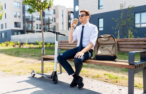 Geschäftsmann mit Roller trinkt Kaffee in der Stadt — Stockfoto