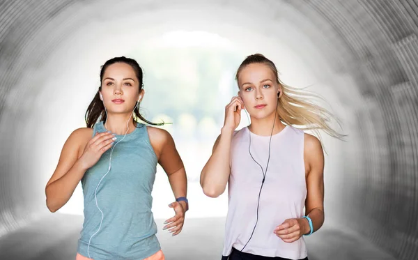 Mujeres o amigas con auriculares funcionando — Foto de Stock