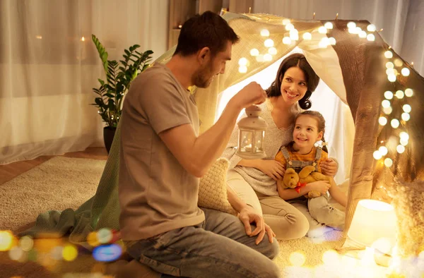 Famille heureuse jouant dans la tente des enfants la nuit à la maison — Photo