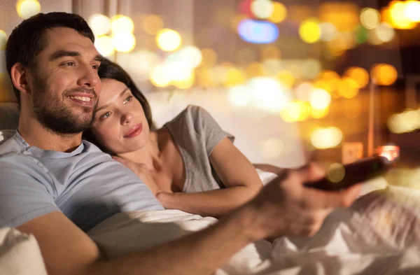 Felice coppia guardando la tv a letto di notte a casa — Foto Stock