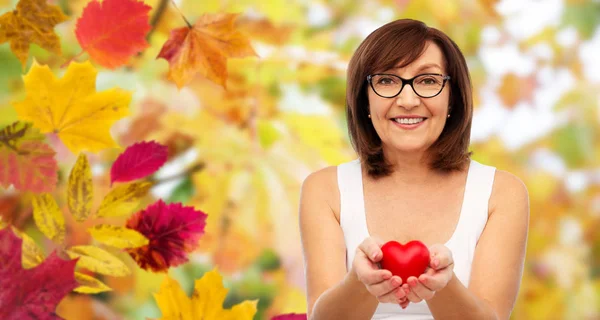 Portret van glimlachen senior vrouw bedrijf rood hart — Stockfoto