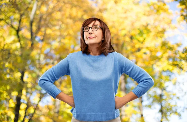 Sonbahar parkı üzerinde gözlük kızgın yaşlı kadın — Stok fotoğraf