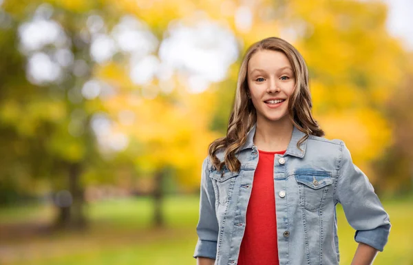 Menina adolescente feliz em jaqueta jeans no parque de outono — Fotografia de Stock