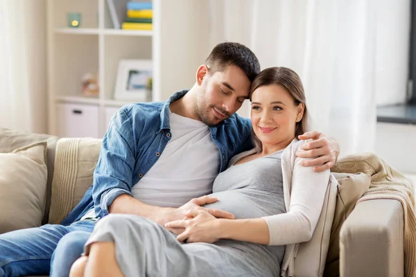 Hombre abrazando a mujer embarazada en casa —  Fotos de Stock