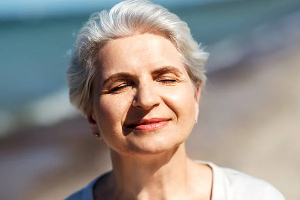 Ritratto di donna anziana che si gode il sole sulla spiaggia — Foto Stock