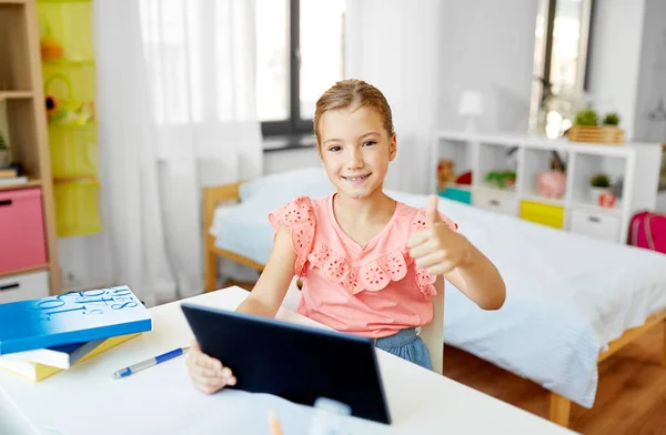 Chica con tablet PC y mostrando los pulgares hacia arriba en casa —  Fotos de Stock
