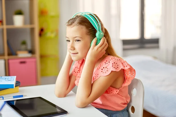 Chica en auriculares con tablet en casa — Foto de Stock