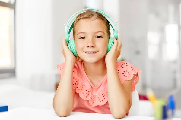 Chica en auriculares escuchando música en casa —  Fotos de Stock