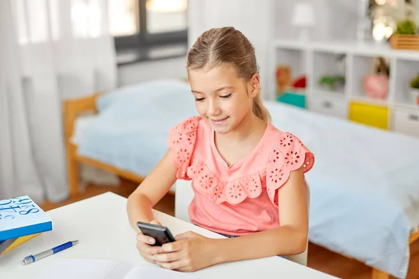 Menina estudante feliz usando smartphone em casa — Fotografia de Stock