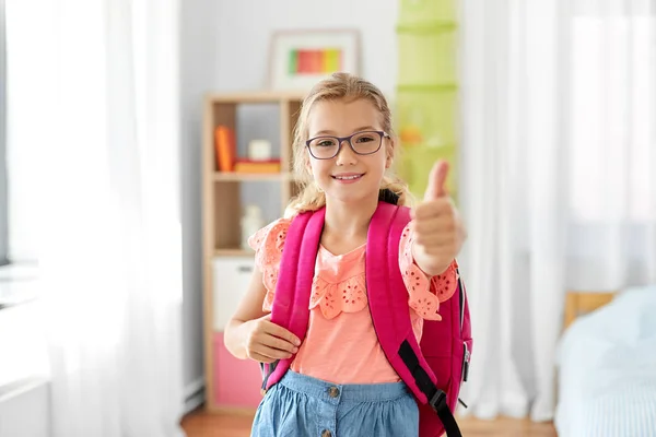 Estudiante chica con la escuela bolsa mostrando pulgares hacia arriba —  Fotos de Stock