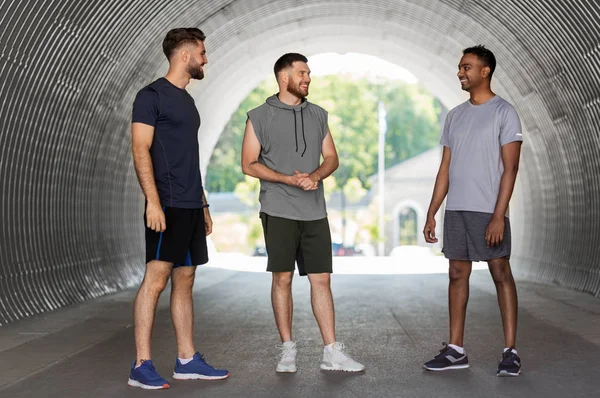 Young sporty men or male friends talking outdoors — Stock Photo, Image