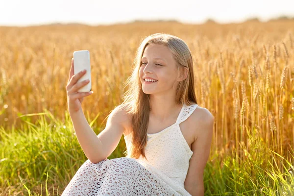 Happy young girl taking selfie by smartphone — Stock Photo, Image