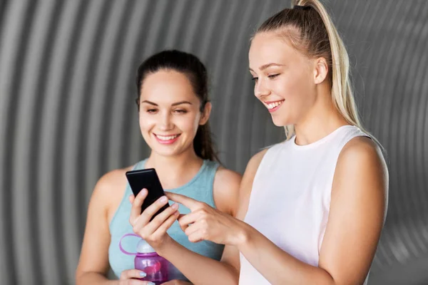 Women or female friends with smartphone and flask — Stock Photo, Image