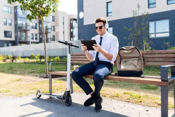 Homme d'affaires avec tablette PC, écouteurs et scooter — Photo